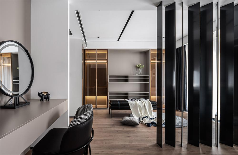 温暖如初、静谧闲适的主卧室,由休憩区、休闲区、衣帽区三部分组成，以灰色为基调，与木色相配，材质转换与色彩变化平缓而自然过渡，端正稳重，井然有序。